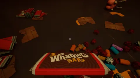 Suelo cubierto de envoltorios y una gran tableta de chocolate